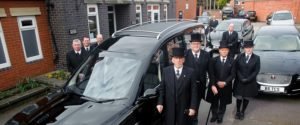 Tamworth Co-op funeral staff standing in front of new Jaguar fleet.