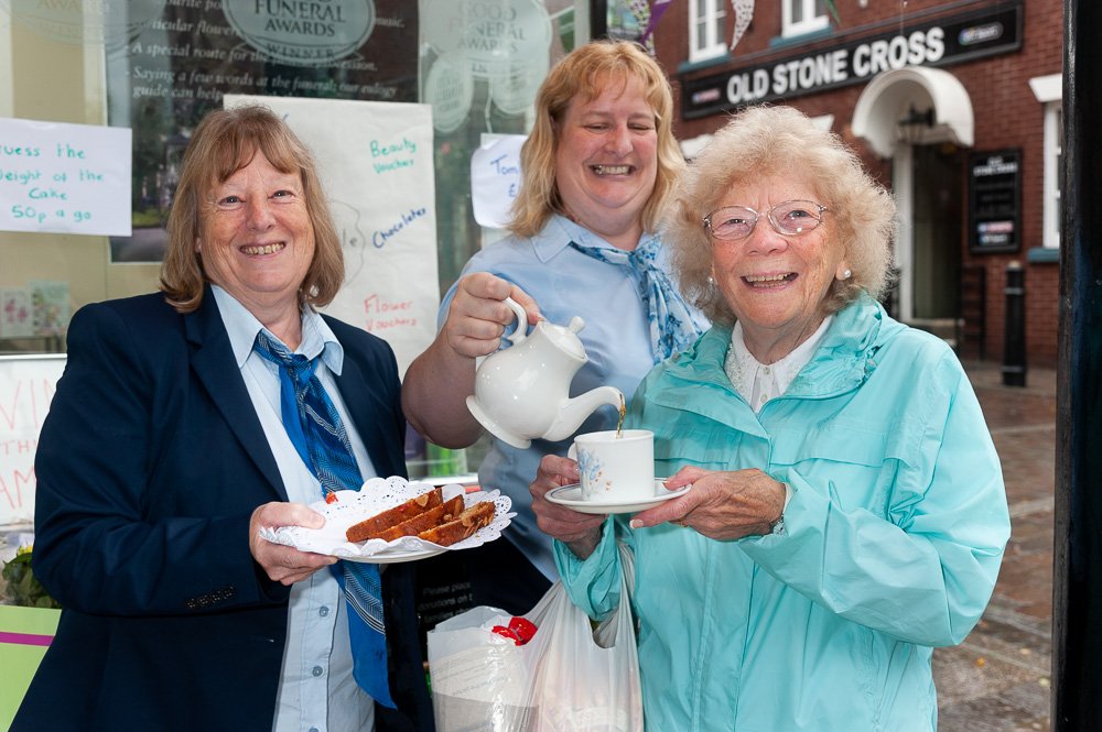 Tamworth Co-op Bereavement Advice Centre funeral arrangers serve up coffee and cake for elderly woman at Macmillan coffee morning