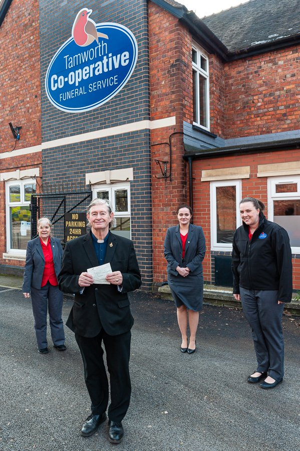 Vicar receiving cheque from Tamworth Co-op funeral staff